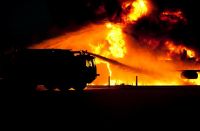 Grafika przedstawiająca wóz strażacki gaszący pożar