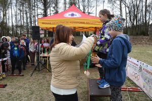 Zdjęcie: młodzież na podium i osoby wręczające nagrody podczas biegów przełajowych