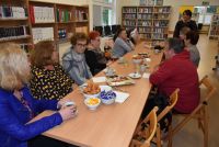 Zdjęcie: Ludzie siedzący przy stoliku podczas spotkania w bibliotece