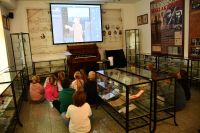 Zdjęcie: dzieci oglądające film historyczny w Izbie Pamięci Rodziny Maklakiewiczów