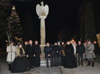 Zdjęcie: przedstawiciele władz samorządowych poraz grupy rekonstrukcyjnej stojący przy pomniku w kształcie orła