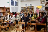 Ludzie siedzący w sali bibliotecznej