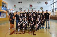 Zdjęcie grupowe młodych koszykarek i ich trenerów z maskotką drużyny Tygrysem