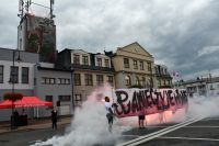 Zdjęcie: Mężczyźni trzymający baner z napisem Pamięć żyje w nas w koło