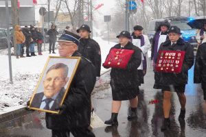 Zdjęcie: Mężczyzna niosący zdjęcie Burmistrza i dwie kobiety niosące jego odznaczenia