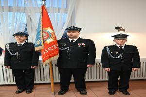 Zdjęcie: trzech strażaków w mundurze stojących ze sztandarem
