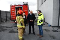 Zdjęcie: przedstawiciele władz samorządowych i strażak na tle wozu strażackiego
