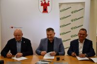 Zdjęcie: trzech mężczyzn podpisujących umowę