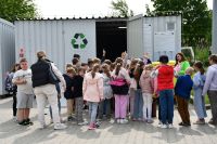 Zdjęcie: uczniowie stojący przed metalowym kontenerem na PSZOKu