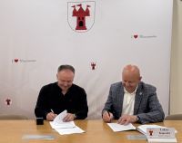 Zdjęcie dwóch mężczyzn podpisujących umowę