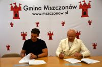 Zdjęcie: dwóch mężczyzn podpisujących umowę