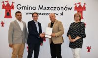 Ludzie na tle ścianki gminy Mszczonów