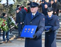 Zdjęcie: policjanci trzymający odznaczenia zmarłego komendanta