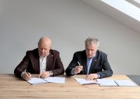 Zdjęcie: dwóch mężczyzn podpisujących umowę