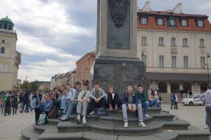 Zdjęcie: młodzież siedząca pod pomnikiem