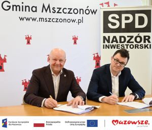 Zdjęcie: dwóch mężczyzn podpisujących umowę, pod zdjęciem loga unijne