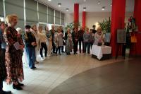 Zdjęcie:  Kobiety i mężczyźni stojący w galerii MOK podczas wernisażu