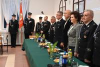 Zdjęcie: przedstawiciele władz samorządowych stojący przy stole podczas walnego zebrania OSP Mszczonów
