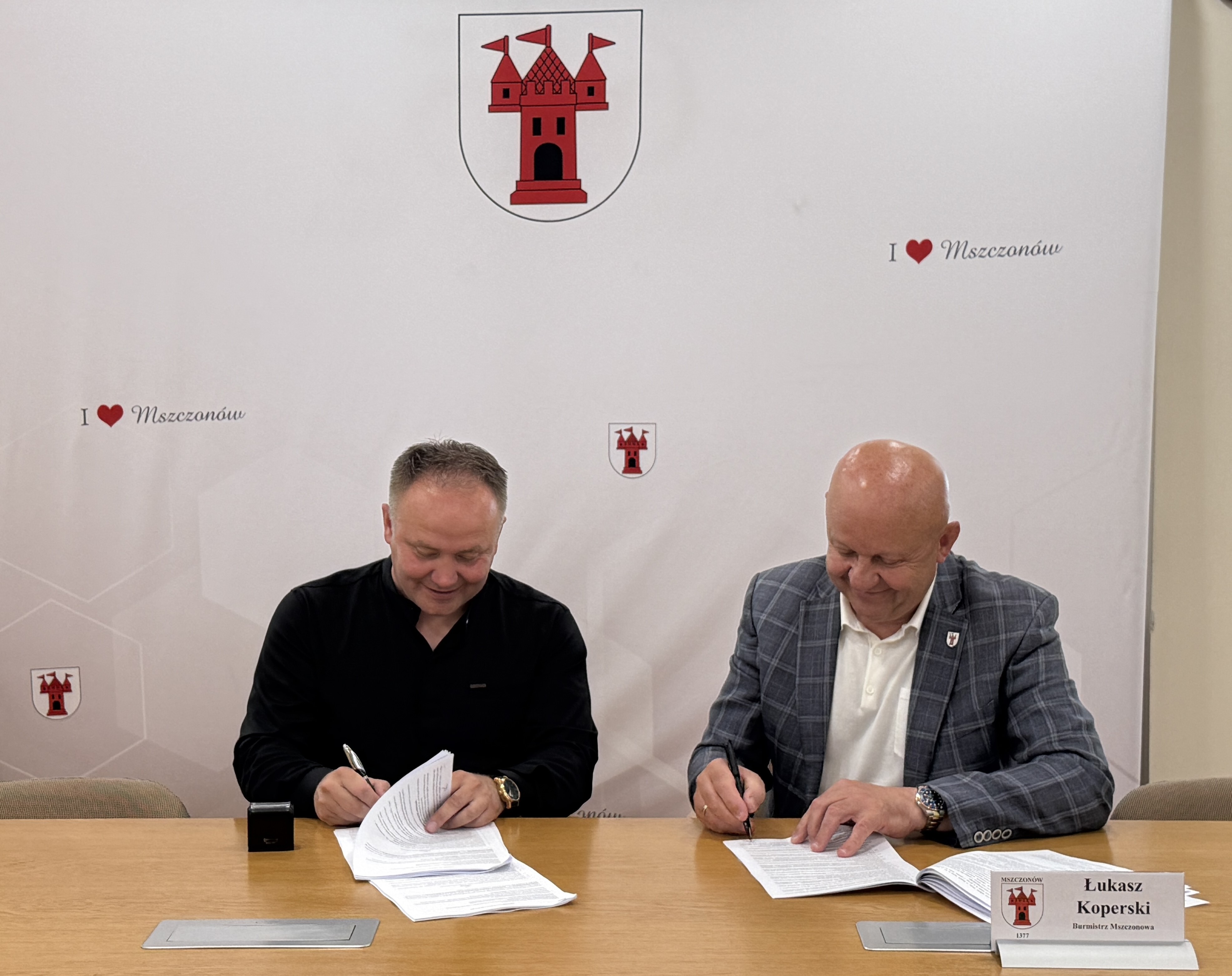 Zdjęcie: dwóch mężczyzn podpisujących umowę
