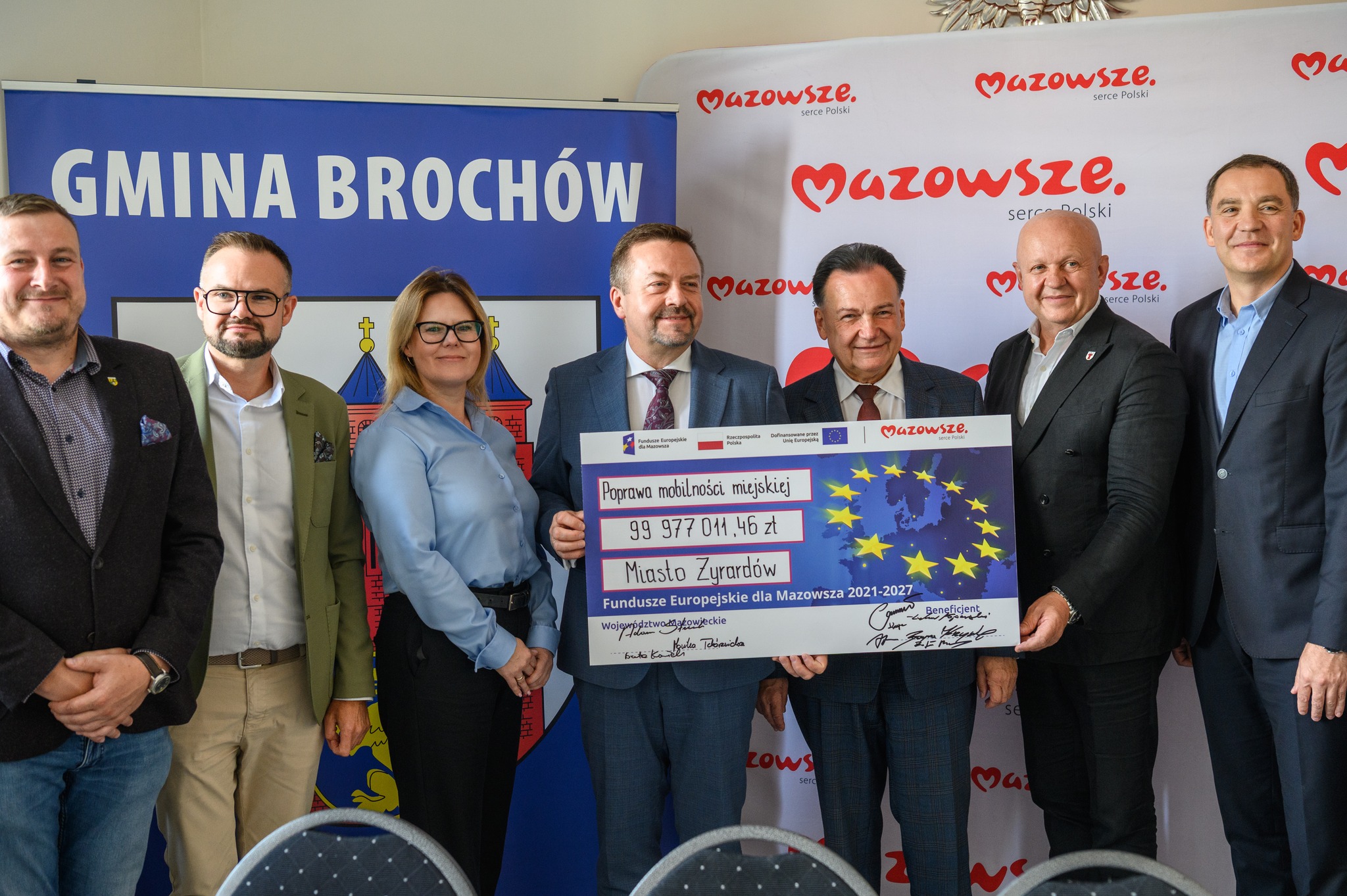 Zdjęcie: osoby stojące z banerem informującym o dofinansowaniu