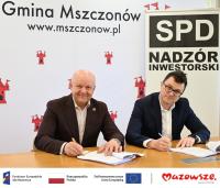 Zdjęcie: dwóch mężczyzn podpisujących umowę, na dole logotypy unijne